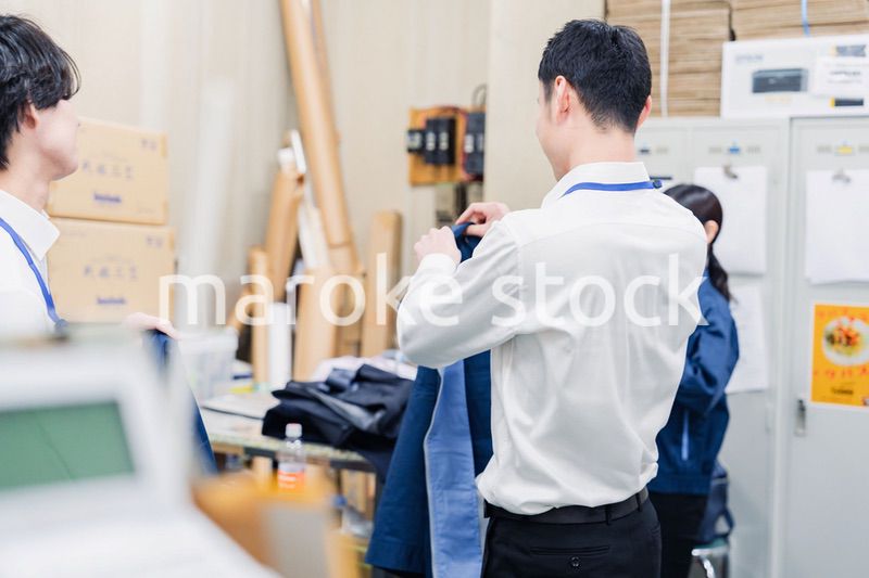 業務終了後にバックヤードで一息をつく従業員