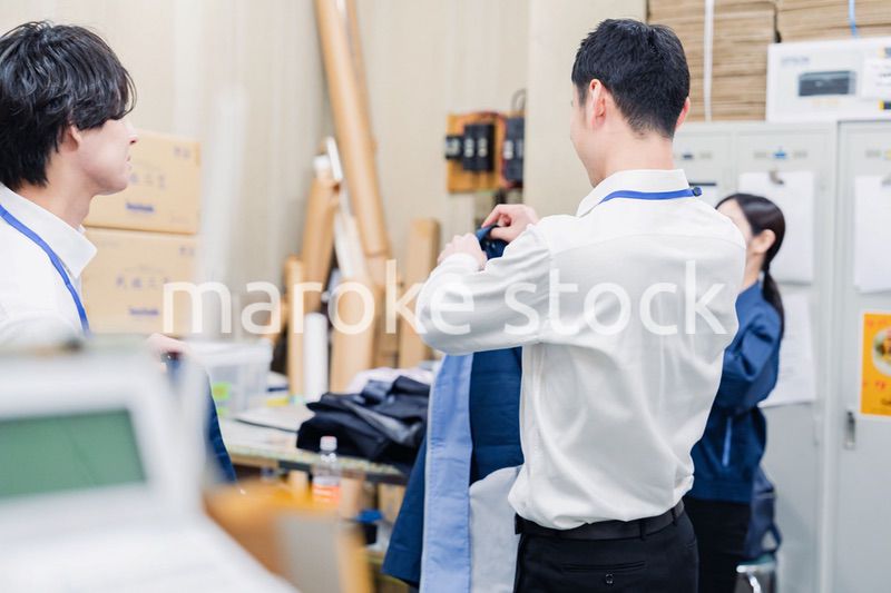 業務終了後にバックヤードで一息をつく従業員