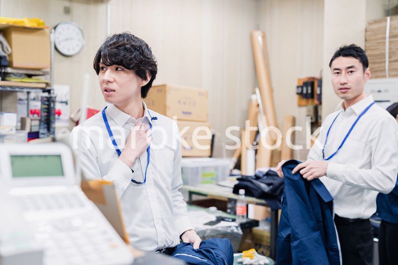 業務終了後にバックヤードで一息をつく従業員