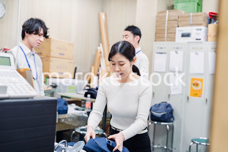 業務終了後にバックヤードで一息をつく従業員