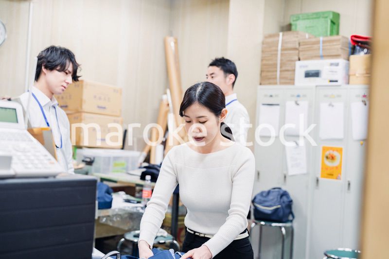 業務終了後にバックヤードで一息をつく従業員