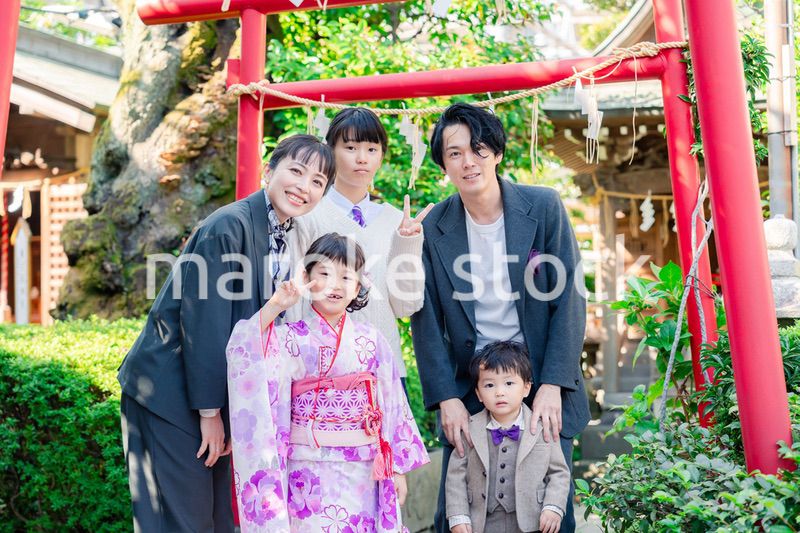 兄弟姉妹揃って神社で七五三のお祝いをする家族