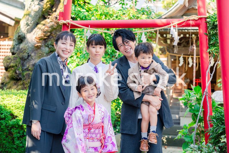 兄弟姉妹揃って神社で七五三のお祝いをする家族
