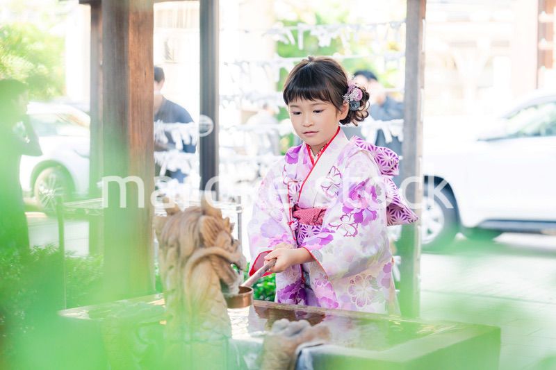 神社の手水舎で手を清める七五三の女の子