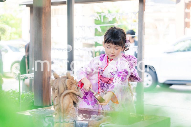神社の手水舎で手を清める七五三の女の子