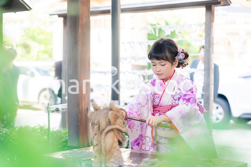 神社の手水舎で手を清める七五三の女の子