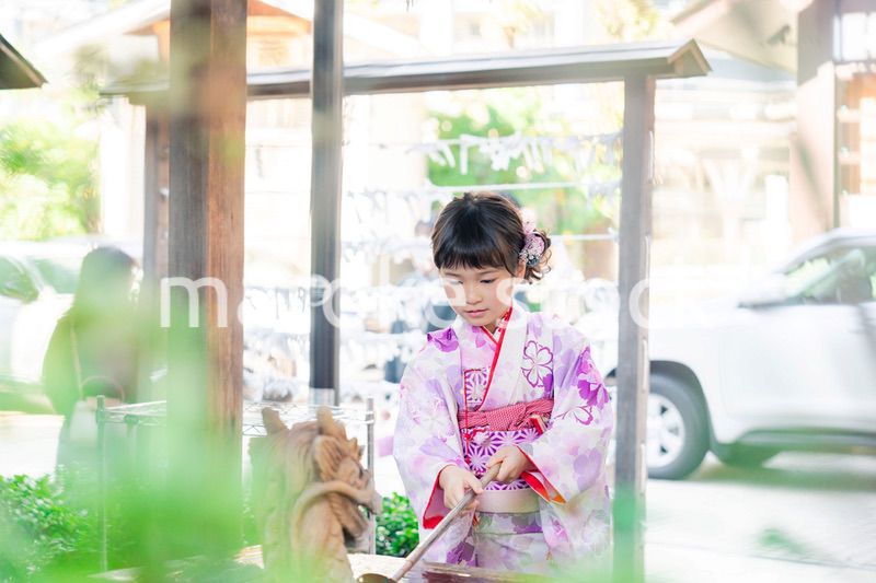 神社の手水舎で手を清める七五三の女の子