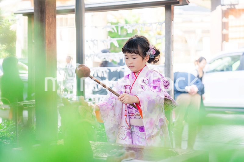 神社の手水舎で手を清める七五三の女の子
