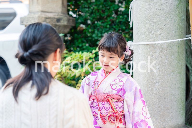 七五三をお祝いする子どもと服を整えるお母さん