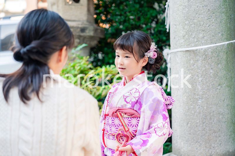 七五三をお祝いする子どもと服を整えるお母さん