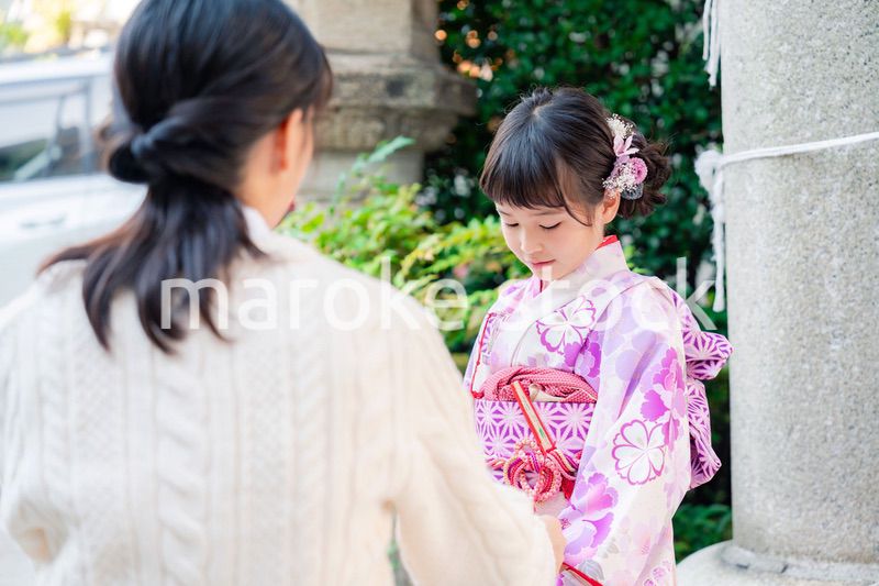 七五三をお祝いする子どもと服を整えるお母さん