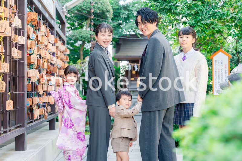 兄弟姉妹揃って神社で七五三のお祝いをする家族