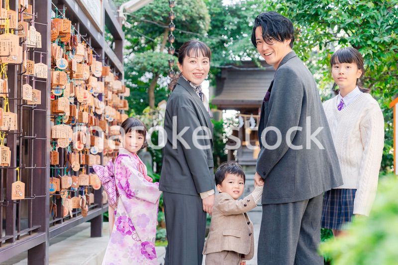 兄弟姉妹揃って神社で七五三のお祝いをする家族
