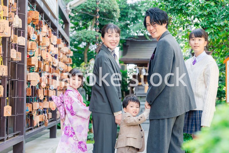 兄弟姉妹揃って神社で七五三のお祝いをする家族