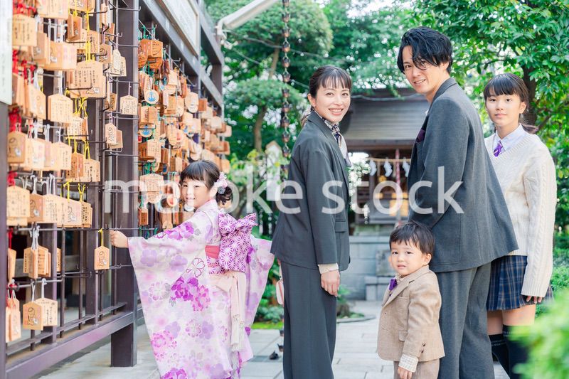 兄弟姉妹揃って神社で七五三のお祝いをする家族