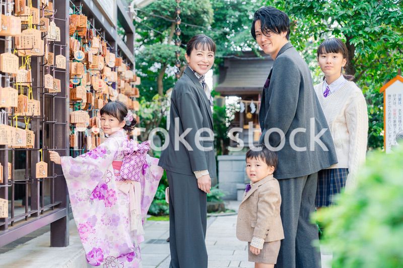 兄弟姉妹揃って神社で七五三のお祝いをする家族