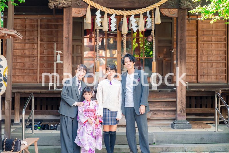 神社で七五三のお祝いをするファミリー