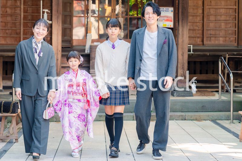 神社で七五三のお祝いをするファミリー
