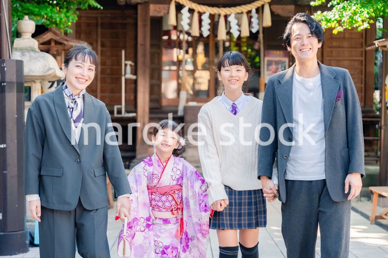 神社で七五三のお祝いをするファミリー
