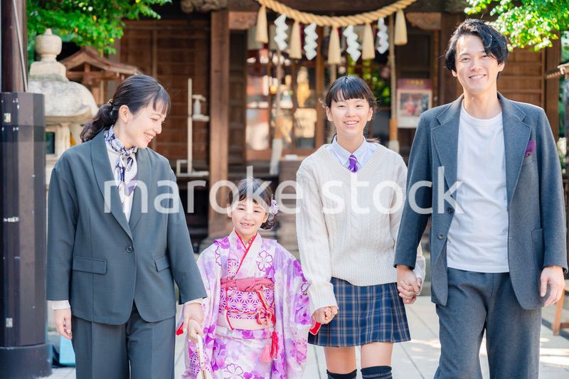 神社で七五三のお祝いをするファミリー