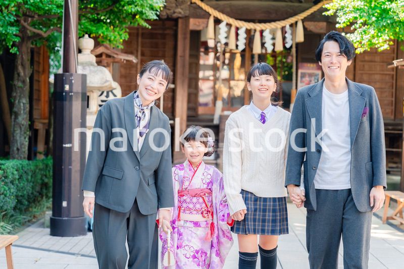 神社で七五三のお祝いをするファミリー