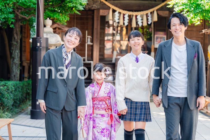 神社で七五三のお祝いをするファミリー