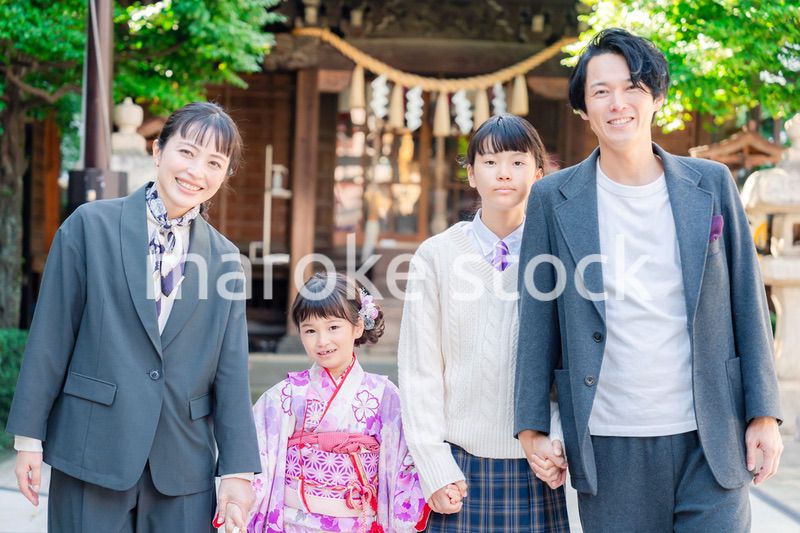 神社で七五三のお祝いをするファミリー