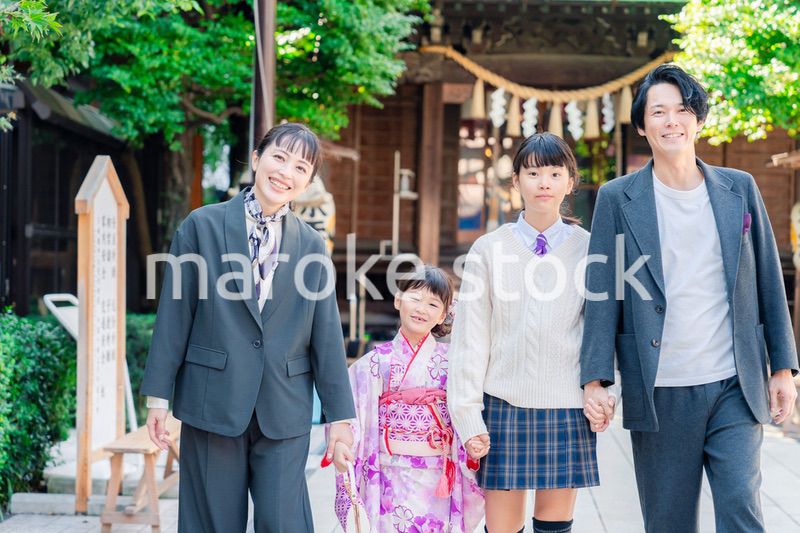 神社で七五三のお祝いをするファミリー