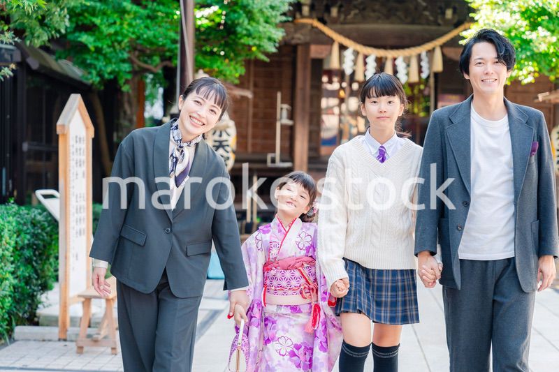 神社で七五三のお祝いをするファミリー