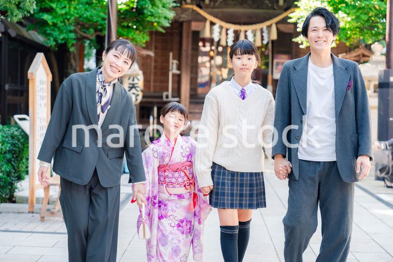 神社で七五三のお祝いをするファミリー