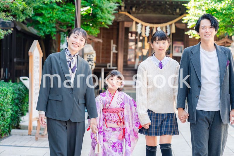 神社で七五三のお祝いをするファミリー