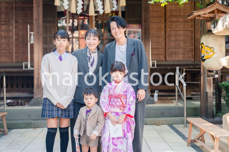 兄弟姉妹揃って神社で七五三のお祝いをする家族