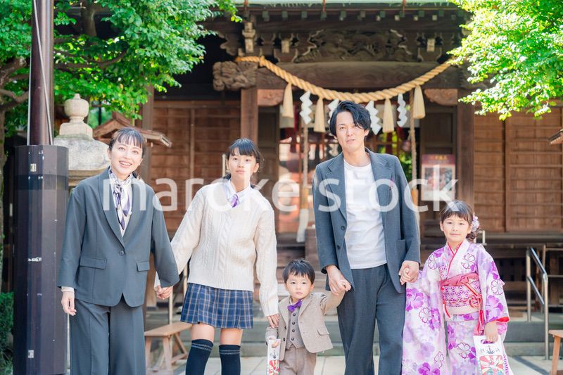 兄弟姉妹揃って神社で七五三のお祝いをする家族