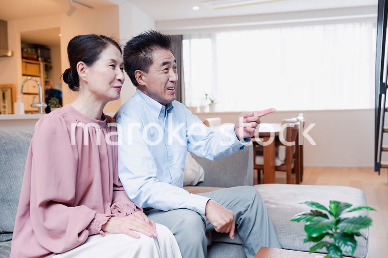 家でテレビを見るシニアの夫婦