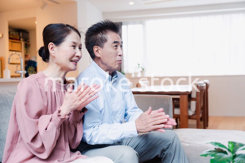 家でテレビを見るシニアの夫婦