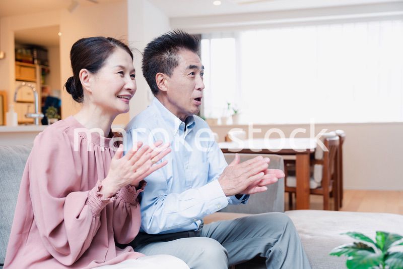 家でテレビを見るシニアの夫婦