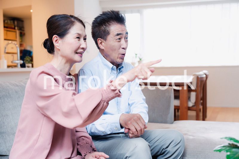家でテレビを見るシニアの夫婦
