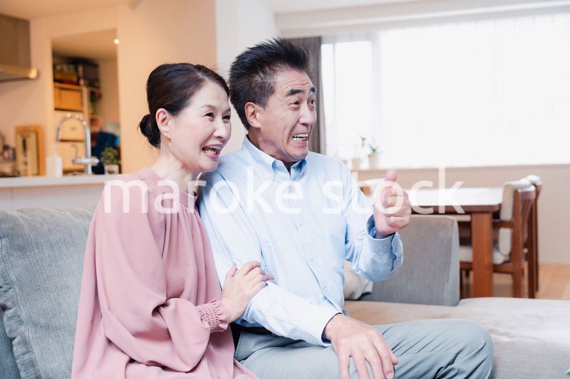 家でテレビを見るシニアの夫婦