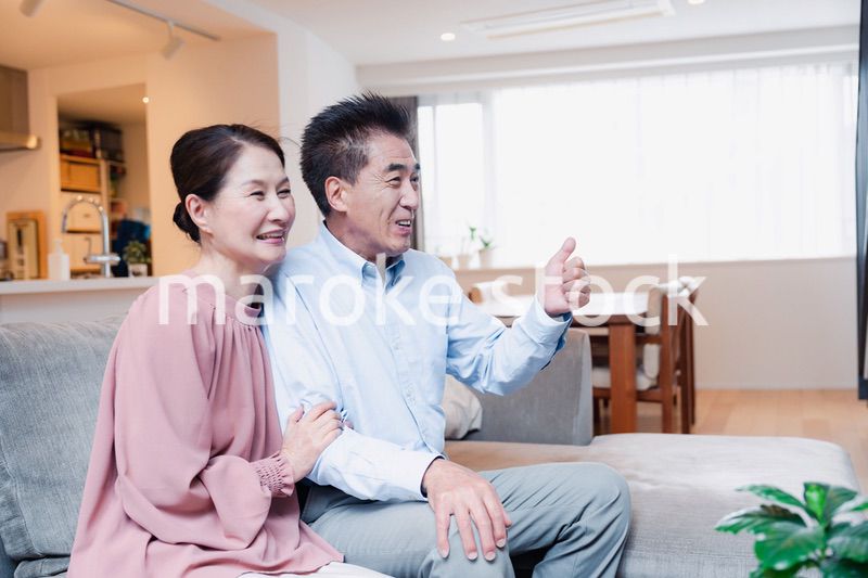 家でテレビを見るシニアの夫婦