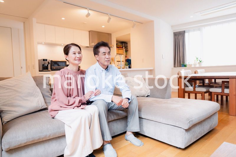 家でテレビを見るシニアの夫婦