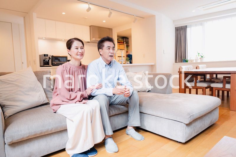 家でテレビを見るシニアの夫婦
