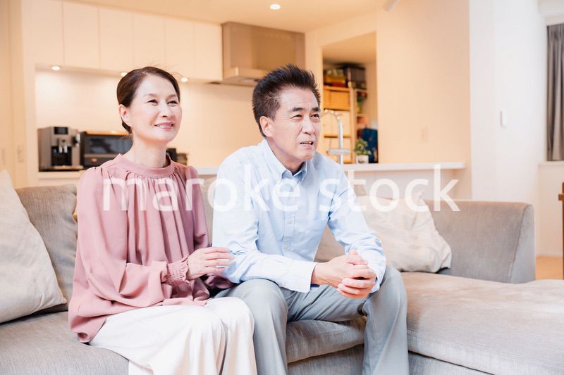 家でテレビを見るシニアの夫婦