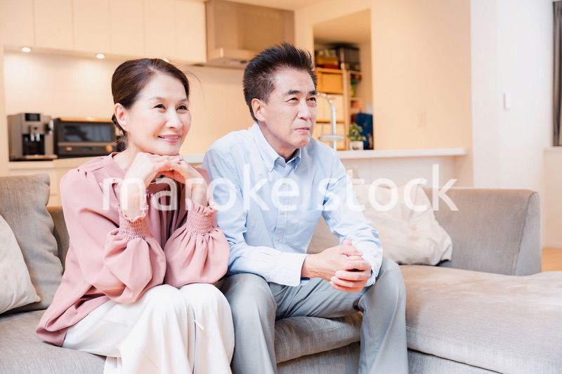 家でテレビを見るシニアの夫婦