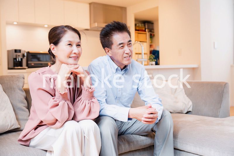 家でテレビを見るシニアの夫婦