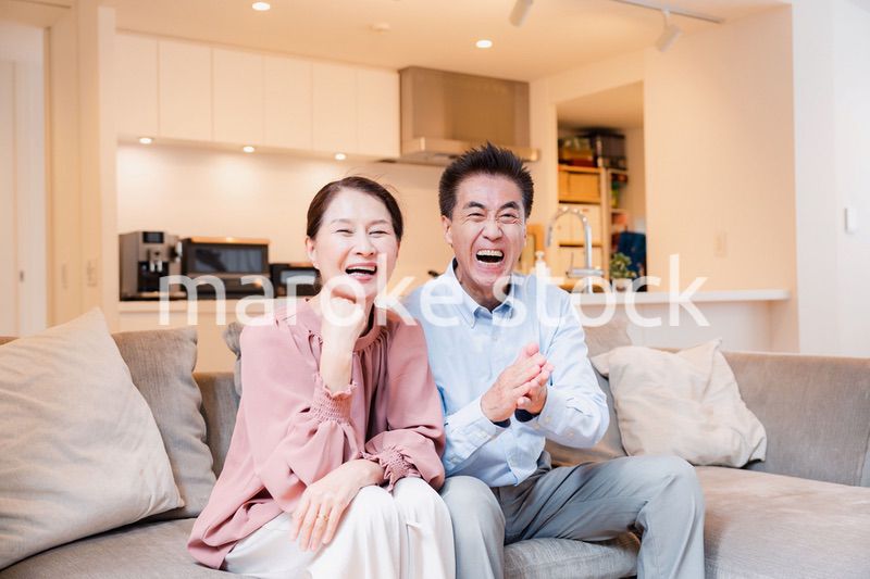 家でテレビを見るシニアの夫婦