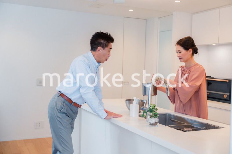 キッチンで一緒にクッキングを楽しむシニアの夫婦