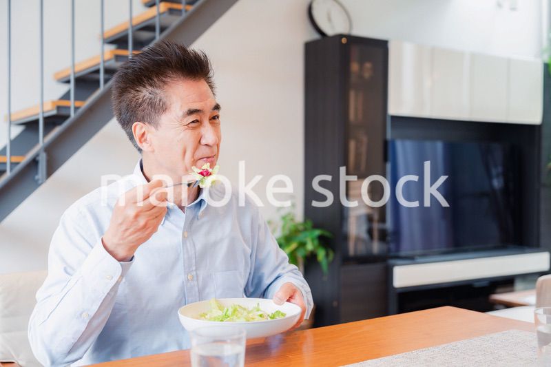 サラダをおいしく食べる高齢の男性