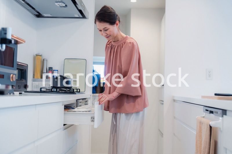 キッチンの収納を工夫するシニアの女性