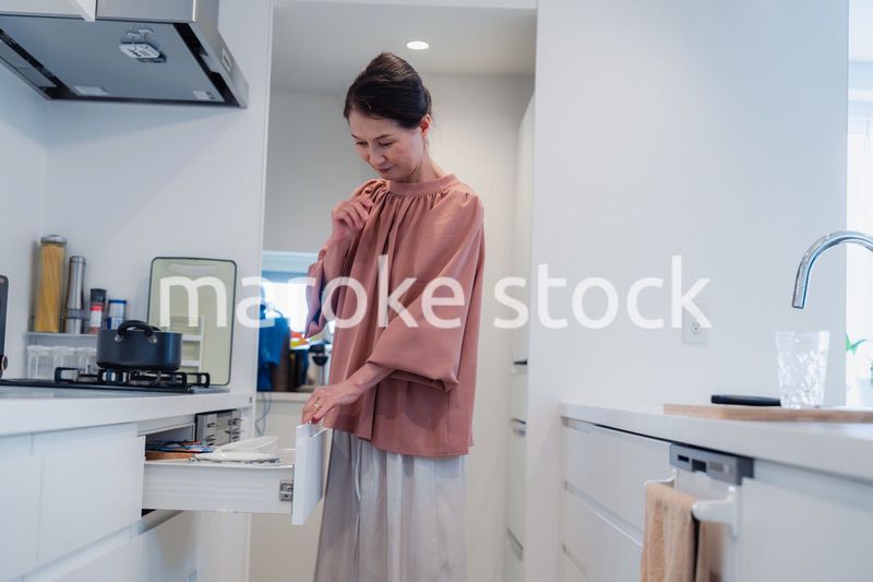 キッチンの収納を工夫するシニアの女性