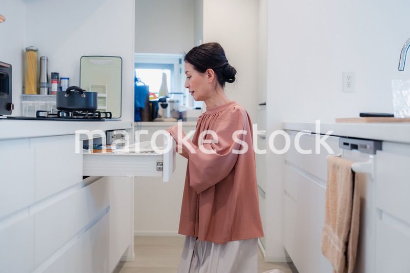 キッチンの収納を工夫するシニアの女性